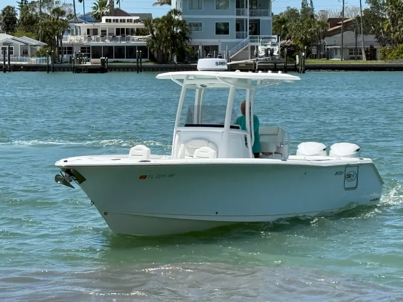 Slide: The Image of 2016 Sea Hunt Gamefish 27 boat cruising on a sunny day near waterfront homes. - 16