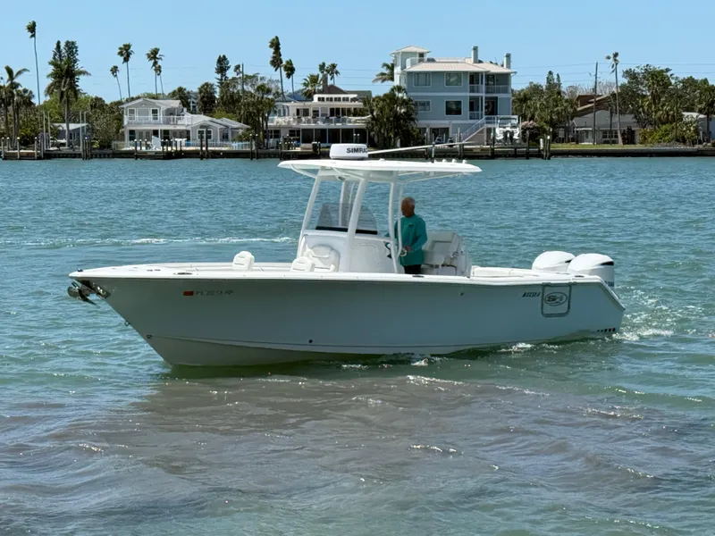 Slide: The Image of 2016 Sea Hunt Gamefish 27 boat on calm water near waterfront homes. - 17
