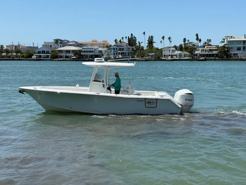 Slide: The Image of 2016 Sea Hunt Gamefish 27 boat cruising on a sunny day near waterfront homes. - 24