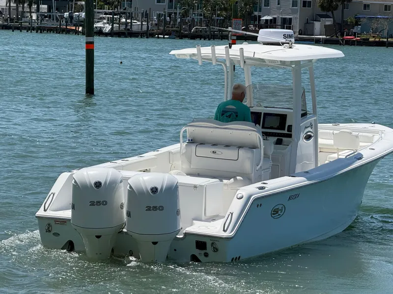 Slide: The Image of 2016 Sea Hunt Gamefish 27 boat with dual engines navigating coastal waters. - 33