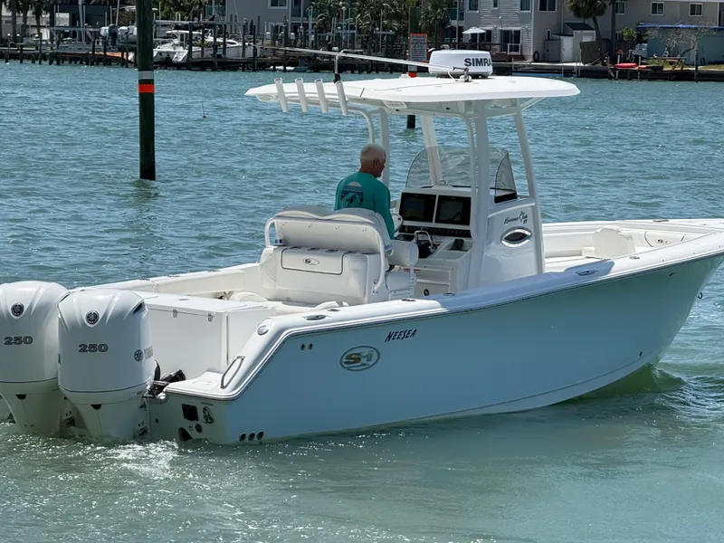 Slide: The Image of 2016 Sea Hunt Gamefish 27 boat with dual engines cruising on clear water. - 35