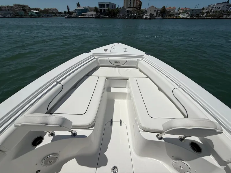 Slide: The Image of 2016 Sea Hunt Gamefish 27 boat interior with white seating on calm water. - 42