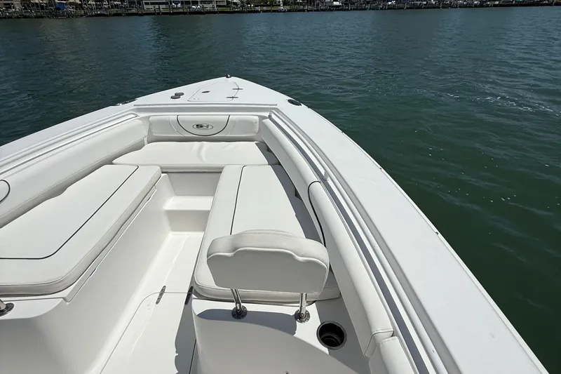 Slide: The Image of 2016 Sea Hunt Gamefish 27 boat interior with white seating on calm water. - 45