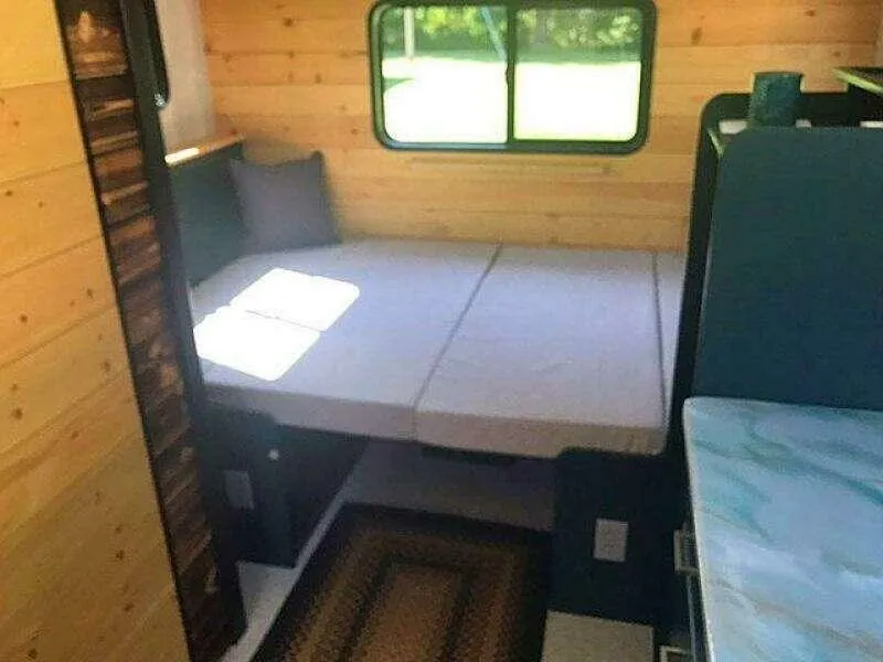 Slide: The Image of Cozy custom camper interior with bed, wooden walls, and window, 2023 model. - 16