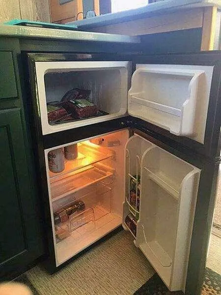 Slide: The Image of Compact refrigerator with open doors, showing stocked freezer and fridge sections, Custom model 25, 2023. - 18