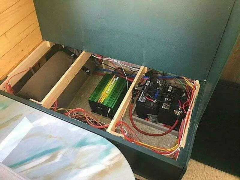 Slide: The Image of Custom 2023 model 25 with exposed battery and wiring setup in a wooden compartment. - 24