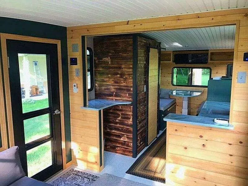 Slide: The Image of Interior of a custom 2023 model 25 tiny home with wood paneling and modern design. - 4