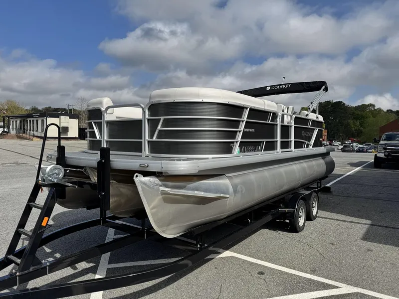 Slide: The Image of 2021 Godfrey Sweetwater 2286 SBX pontoon boat on trailer in parking lot. - 2