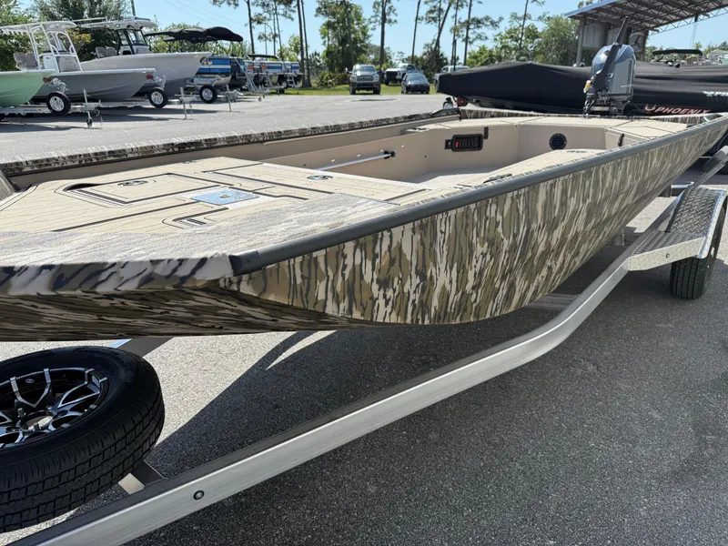 Slide: The Image of 2025 Avid 18 Commander boat with camouflage design on a trailer in a parking lot. - 3