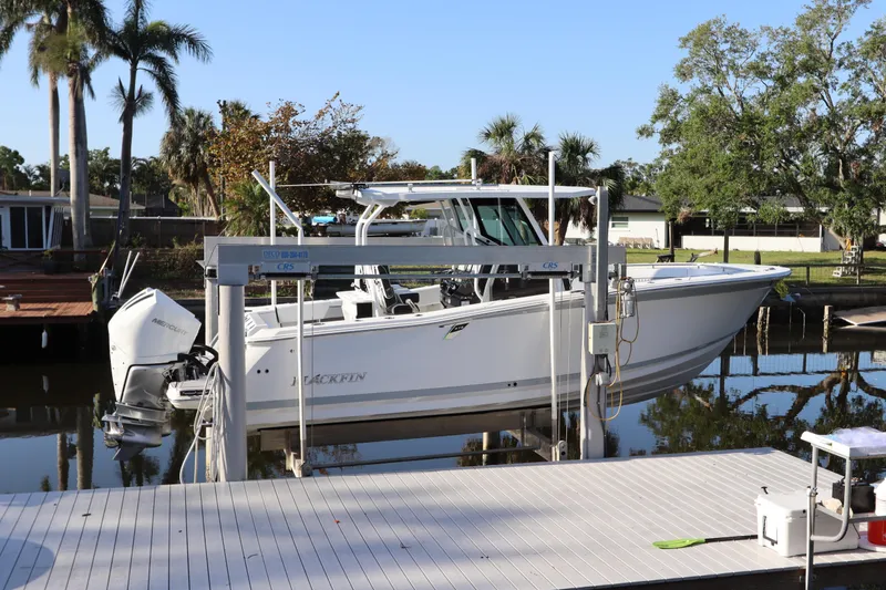Slide: The Image of 2023 Blackfin 272 CC boat docked by a waterfront with palm trees. - 1