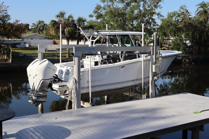 Slide: The Image of 2023 Blackfin 272 CC boat on lift by waterfront dock. - 2