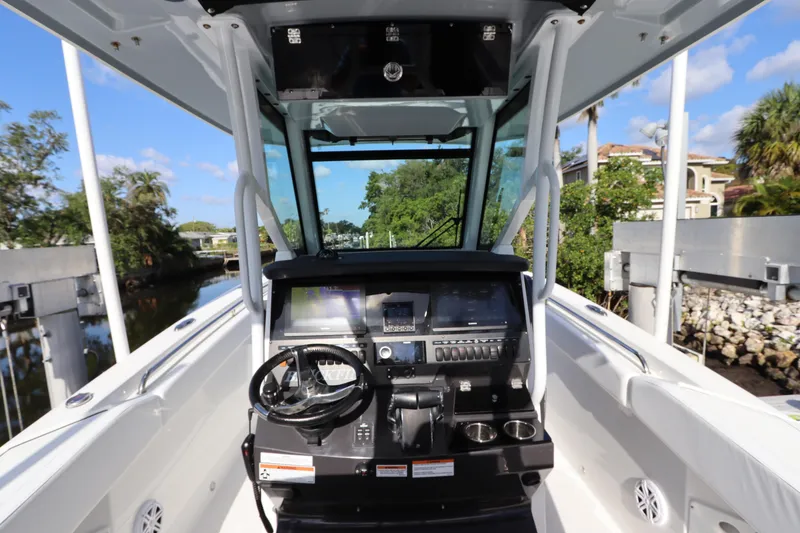 Slide: The Image of 2023 Blackfin 272 CC boat cockpit with modern controls and scenic waterway view. - 20