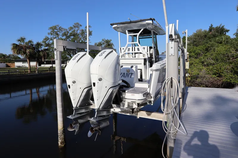 Slide: The Image of 2023 Blackfin 272 CC boat with dual outboard engines on a dock lift. - 3