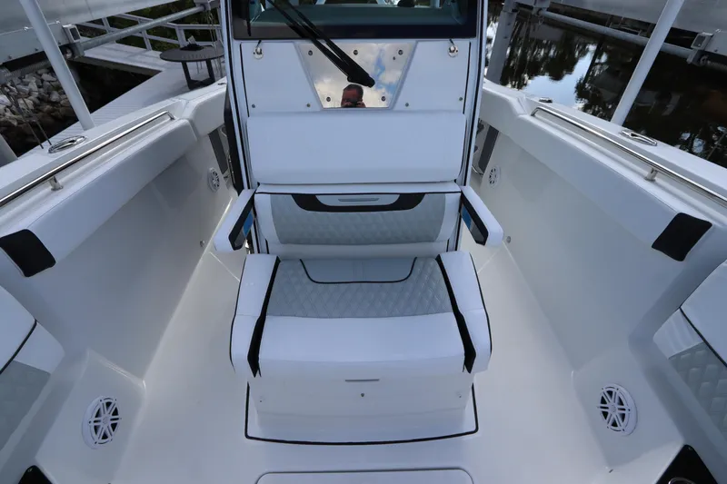 Slide: The Image of 2023 Blackfin 272 CC boat interior with seating and console, docked by the water. - 35