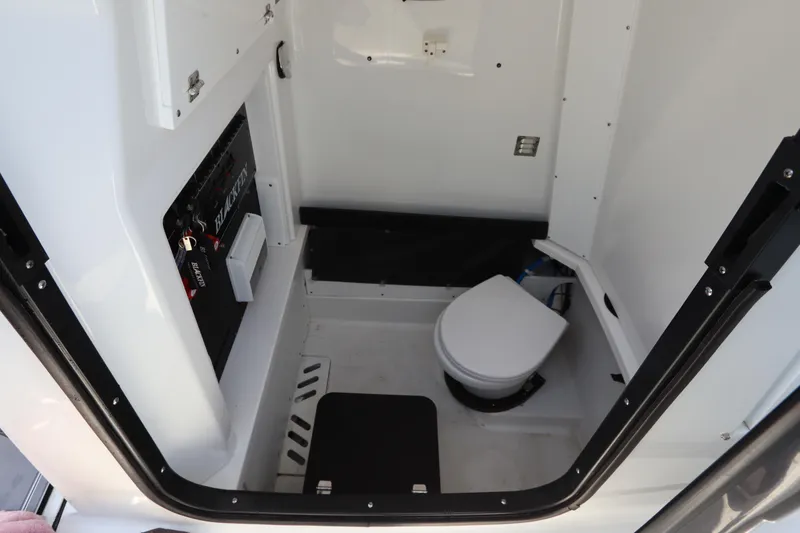 Slide: The Image of 2023 Blackfin 272 CC boat interior with compact marine toilet and control panel. - 38
