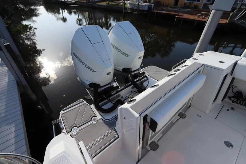 Slide: The Image of 2023 Blackfin 272 CC boat with dual Mercury outboard engines on a calm waterway. - 6