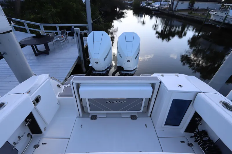Slide: The Image of 2023 Blackfin 272 CC boat with dual engines docked by a serene waterfront. - 7
