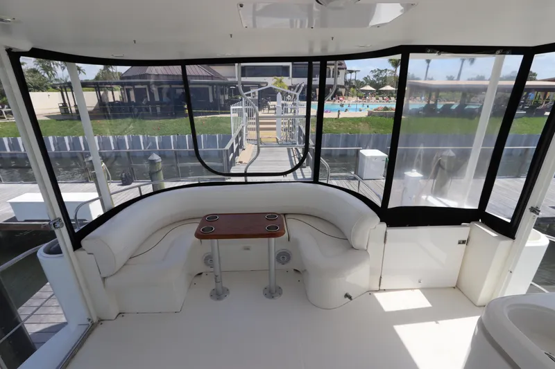 Slide: The Image of 2000 Cruisers Yachts 4450 Express Motoryacht interior with white seating and wooden table. - 11