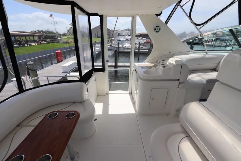 Slide: The Image of 2000 Cruisers Yachts 4450 Express Motoryacht interior with white seating and wooden table. - 15