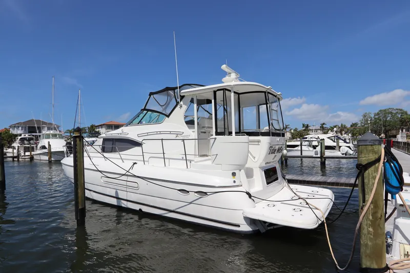 Slide: The Image of 2000 Cruisers Yachts 4450 Express Motoryacht docked in a marina under clear skies. - 2