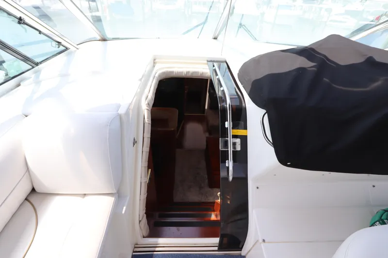 Slide: The Image of 2000 Cruisers Yachts 4450 Express Motoryacht interior entrance with white seating and covered controls. - 25