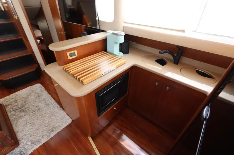 Slide: The Image of 2000 Cruisers Yachts 4450 Express Motoryacht kitchen with wood cabinetry and modern appliances. - 30