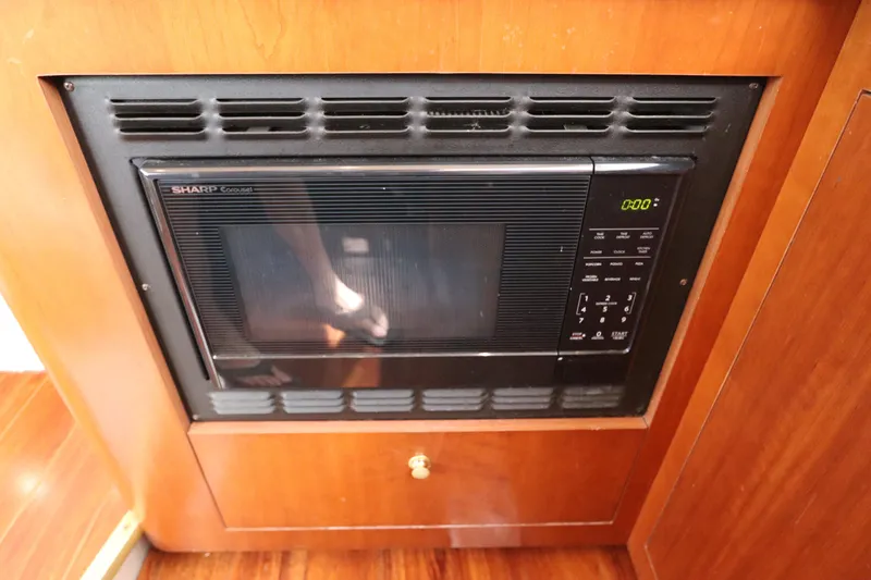 Slide: The Image of Microwave in 2000 Cruisers Yachts 4450 Express Motoryacht kitchen, set in wooden cabinetry. - 31