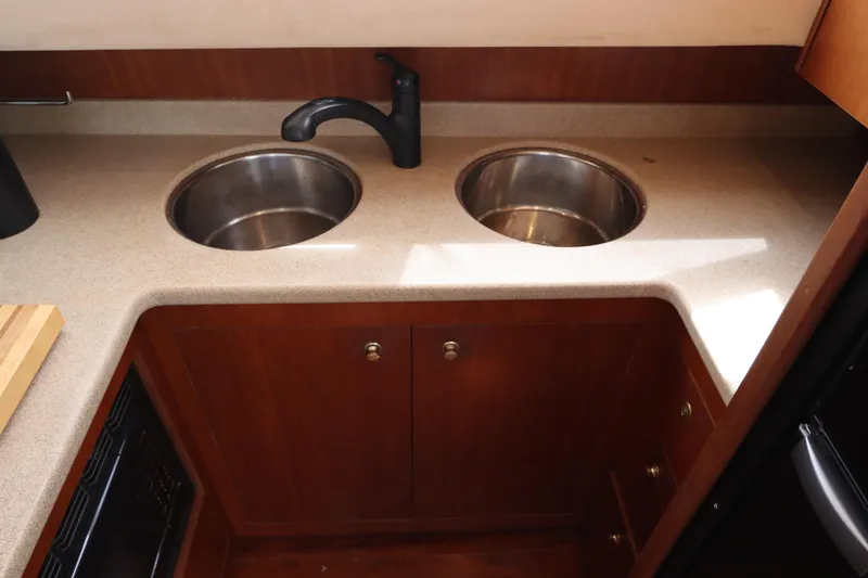 Slide: The Image of 2000 Cruisers Yachts 4450 Express Motoryacht kitchen with dual sinks and wooden cabinetry. - 32