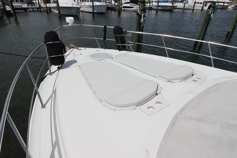 Slide: The Image of 2000 Cruisers Yachts 4450 Express Motoryacht bow with sun pads at marina. - 4