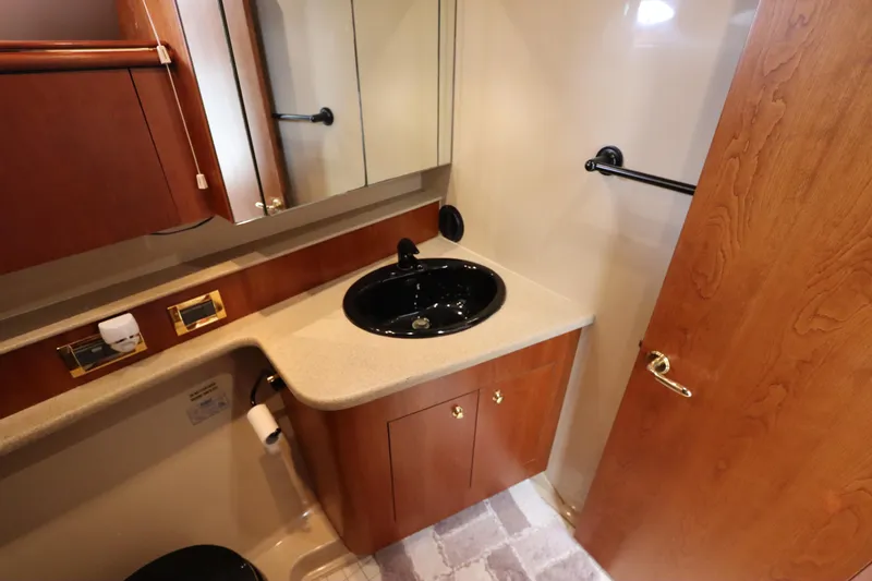 Slide: The Image of Luxurious bathroom in 2000 Cruisers Yachts 4450 Express Motoryacht with wood cabinetry and black sink. - 41