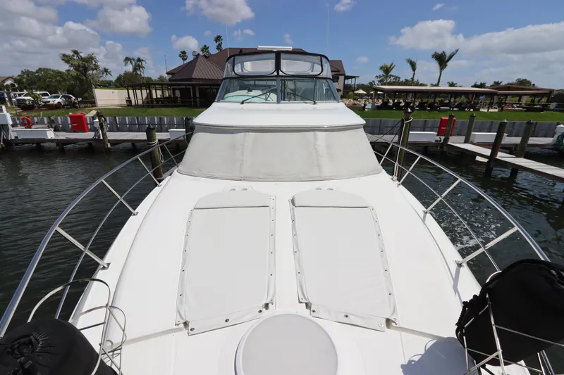Slide: The Image of 2000 Cruisers Yachts 4450 Express Motoryacht docked, showcasing spacious deck and sleek design. - 6