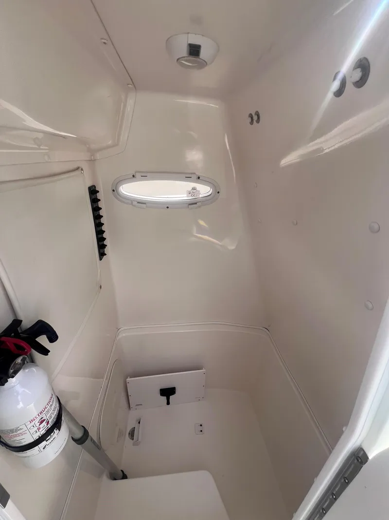 Slide: The Image of Interior cabin of 2014 Cobia 201 Center Console boat with porthole and fire extinguisher. - 13