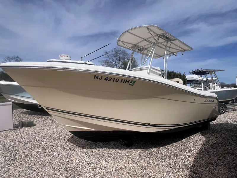Slide: The Image of 2014 Cobia 201 Center Console boat on gravel, under a clear sky. - 3