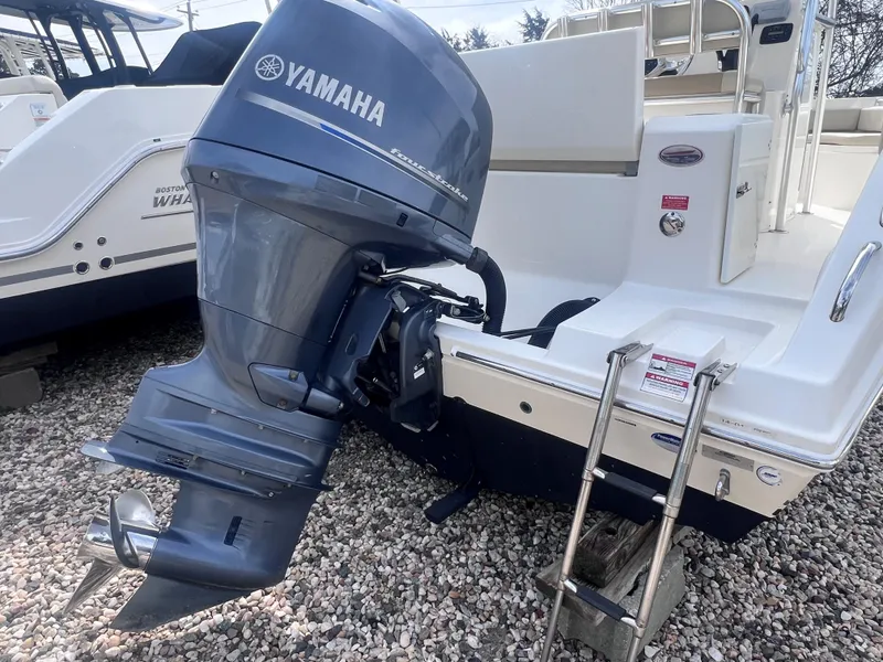 Slide: The Image of 2014 Cobia 201 Center Console with Yamaha outboard motor and ladder on gravel. - 4