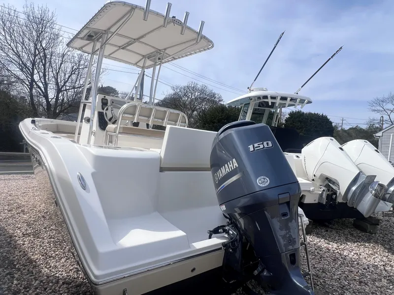Slide: The Image of 2014 Cobia 201 Center Console boat with Yamaha 150 engine, parked on gravel. - 6