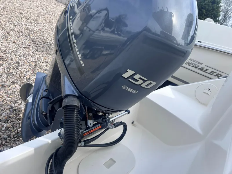 Slide: The Image of 2014 Cobia 201 Center Console with Yamaha 150 outboard motor, on gravel surface. - 7