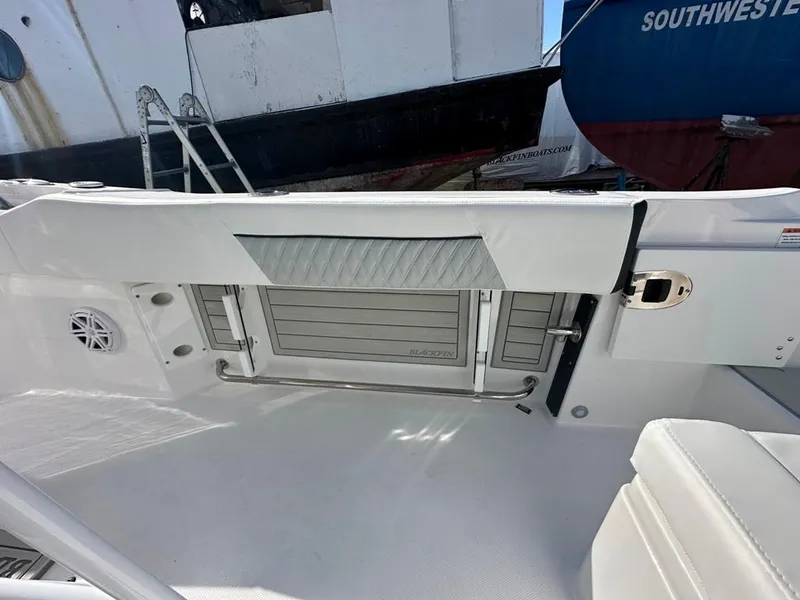 Slide: The Image of 2024 Blackfin 222CC boat interior with storage compartment and seating area. - 14