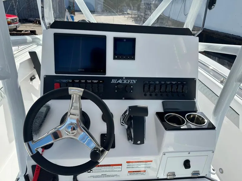 Slide: The Image of 2024 Blackfin 222CC boat dashboard with steering wheel, digital displays, and control panel. - 20