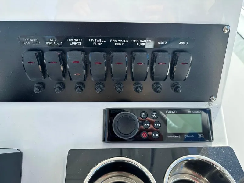 Slide: The Image of Control panel of 2024 Blackfin 222CC boat with switches and Fusion stereo system. - 24