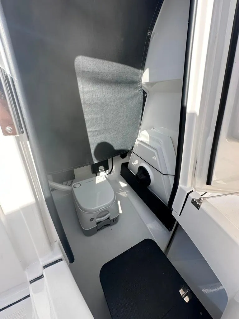 Slide: The Image of 2024 Blackfin 222CC boat interior with compact marine toilet. - 25
