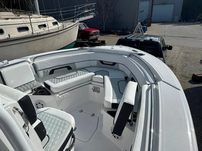 Slide: The Image of 2024 Blackfin 222CC boat interior with seating and cup holders, docked near other boats. - 26