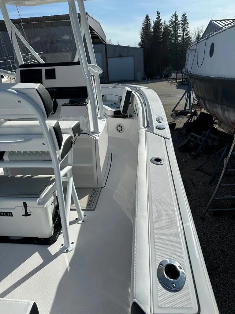 Slide: The Image of 2024 Blackfin 222CC boat docked, showcasing sleek design and spacious deck layout. - 5