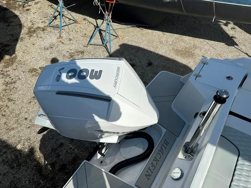 Slide: The Image of 2024 Blackfin 222CC boat with Mercury 300 outboard engine, docked on gravel. - 8
