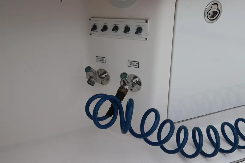 Slide: The Image of 2007 Cabo 40 Hardtop Express boat controls with blue coiled hose and labeled valves. - 16