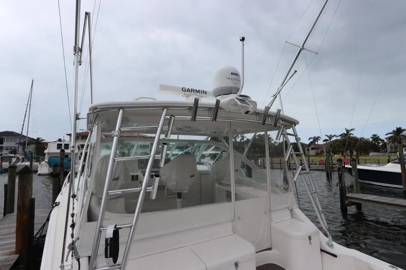 Slide: The Image of 2007 Cabo 40 Hardtop Express boat docked, featuring Garmin equipment and fishing rods. - 20