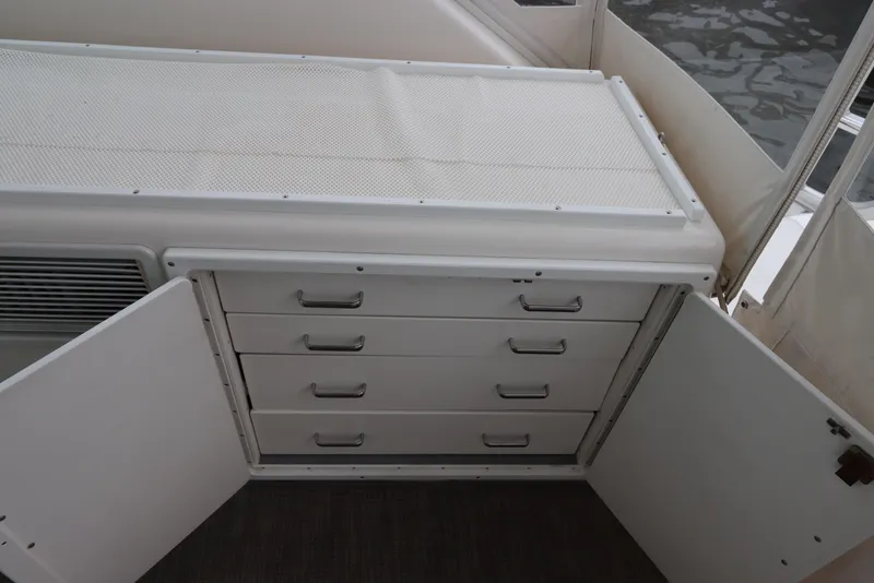 Slide: The Image of 2007 Cabo 40 Hardtop Express interior storage with open cabinet and drawers. - 26