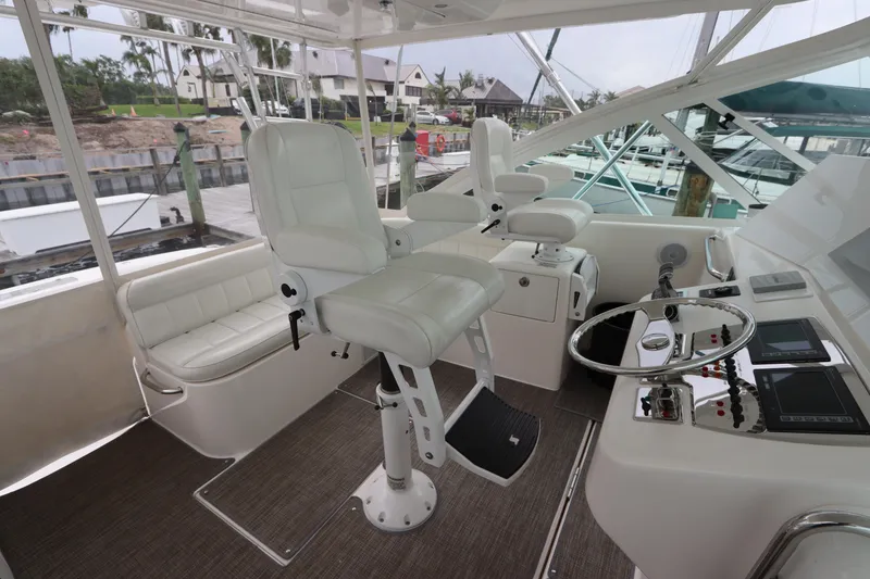 Slide: The Image of 2007 Cabo 40 Hardtop Express helm with white seating and control panel. - 27