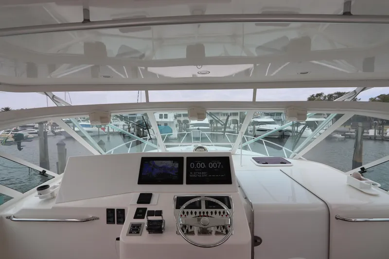 Slide: The Image of 2007 Cabo 40 Hardtop Express helm with navigation screens and marina view. - 28