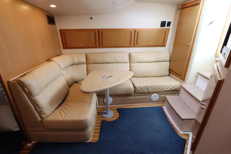 Slide: The Image of 2007 Cabo 40 Hardtop Express interior with beige seating, wooden accents, and blue carpet. - 38