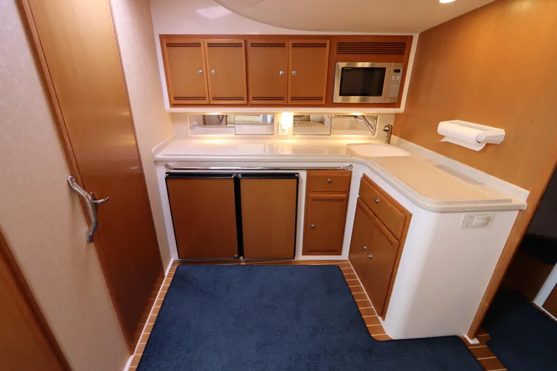 Slide: The Image of 2007 Cabo 40 Hardtop Express yacht kitchen with wood cabinets and modern appliances. - 40